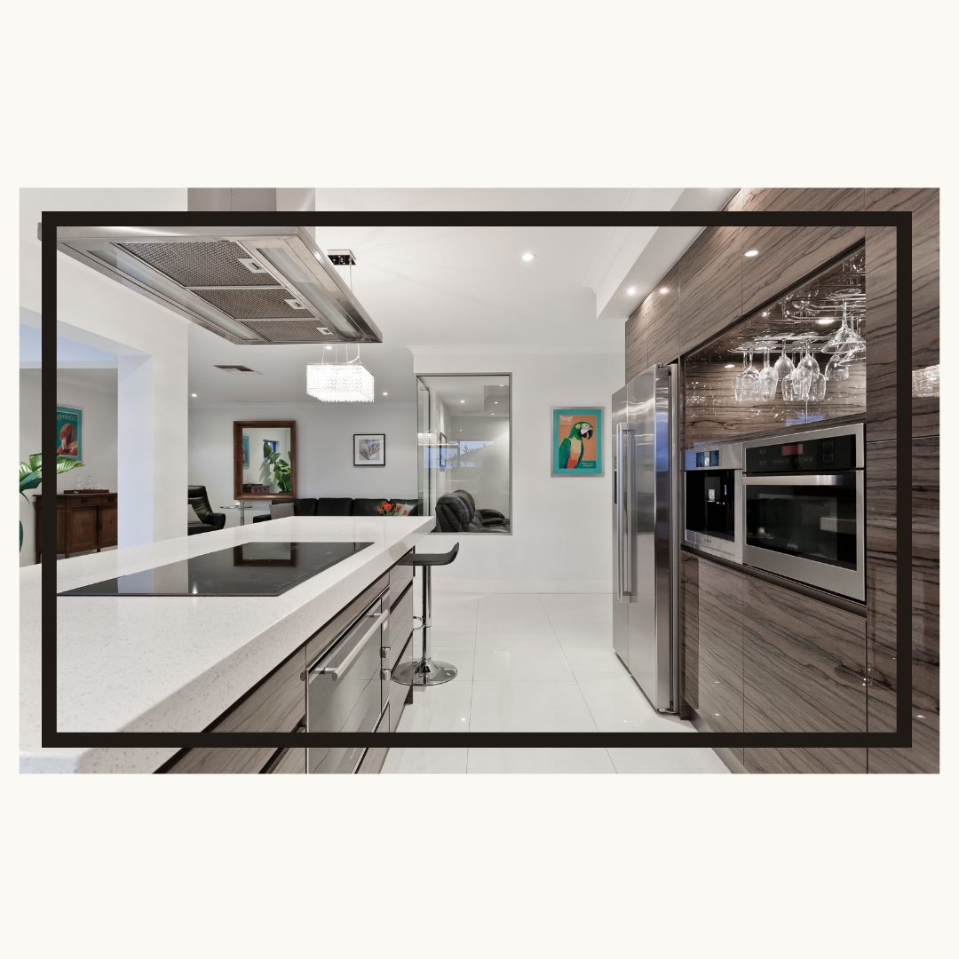 Modern open-concept kitchen with white quartz countertops, wood-grain cabinets, stainless steel appliances, and bar seating overlooking living area
